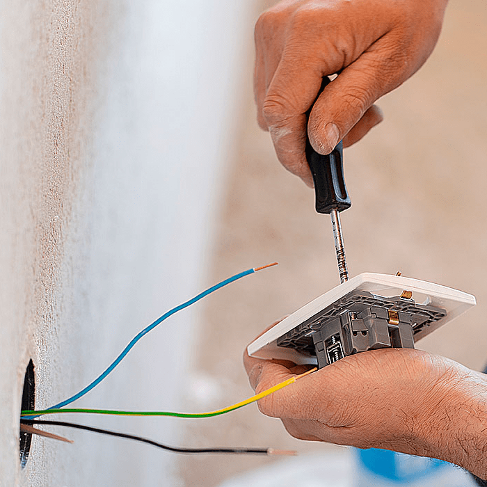 Electricista arreglando cableado con destornillador